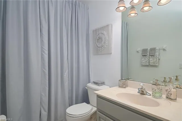 a bathroom with a sink vanity mirror and toilet