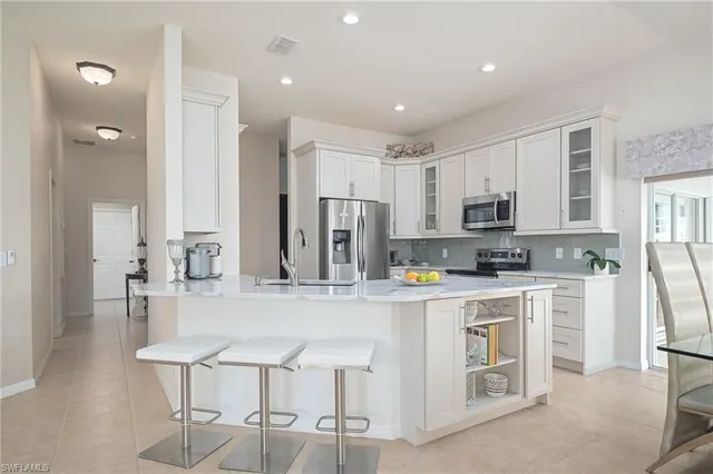 a kitchen with stainless steel appliances kitchen island granite countertop a refrigerator and microwave