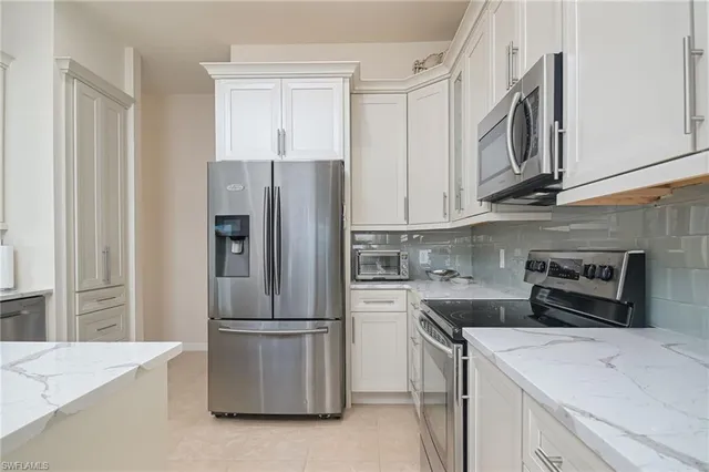a kitchen with stainless steel appliances granite countertop a refrigerator and a stove