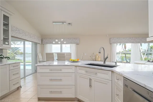 a kitchen with cabinets appliances a sink and a large window