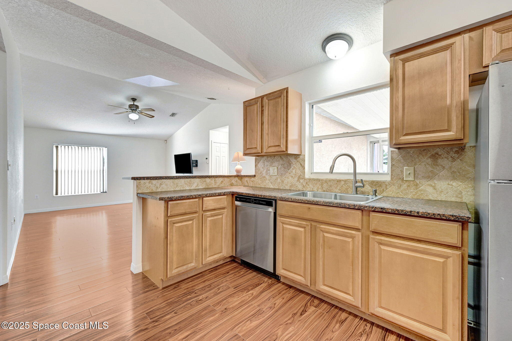 6094 Cardiff Avenue Cocoa, FL 32927 - Photo 15 of 48 a kitchen with granite countertop a sink cabinets stainless steel appliances and a window