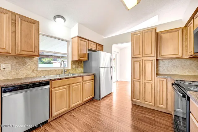 a kitchen with stainless steel appliances granite countertop a refrigerator sink and cabinets