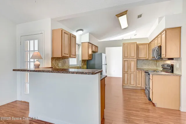 a kitchen with stainless steel appliances granite countertop a refrigerator a stove top oven a sink and dishwasher