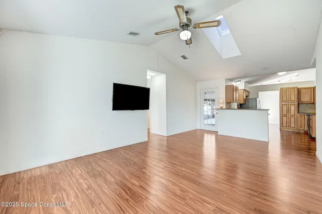 a view of a livingroom with wooden floor and a ceiling fan