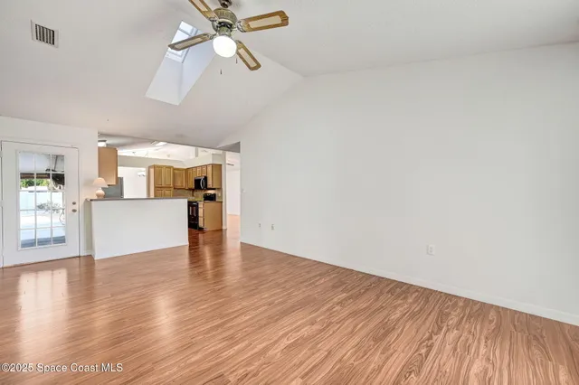 a view of empty room with wooden floor