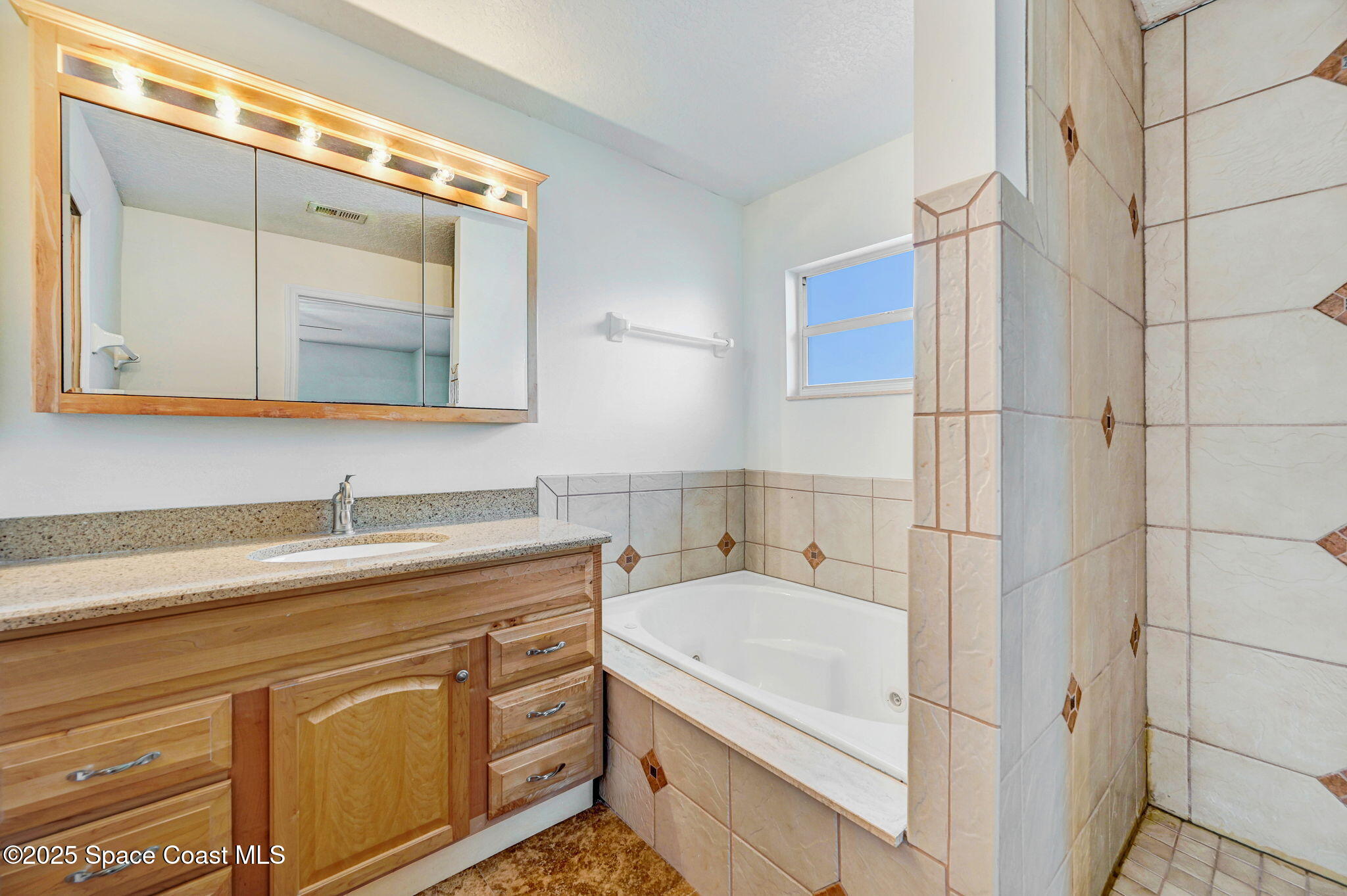 6094 Cardiff Avenue Cocoa, FL 32927 - Photo 27 of 48 a bathroom with a granite countertop sink a mirror and a shower