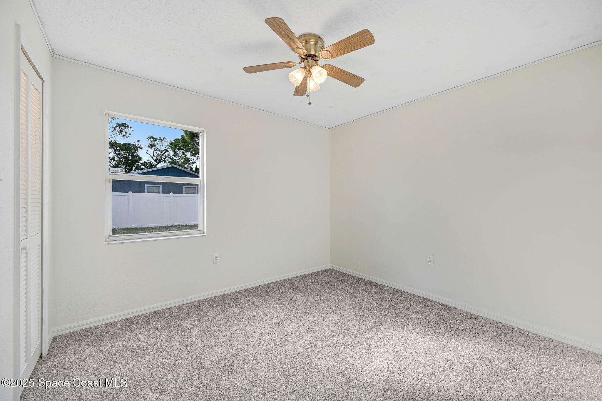 6094 Cardiff Avenue Cocoa, FL 32927 - Photo 30 of 48 an empty room with a window and a ceiling fan