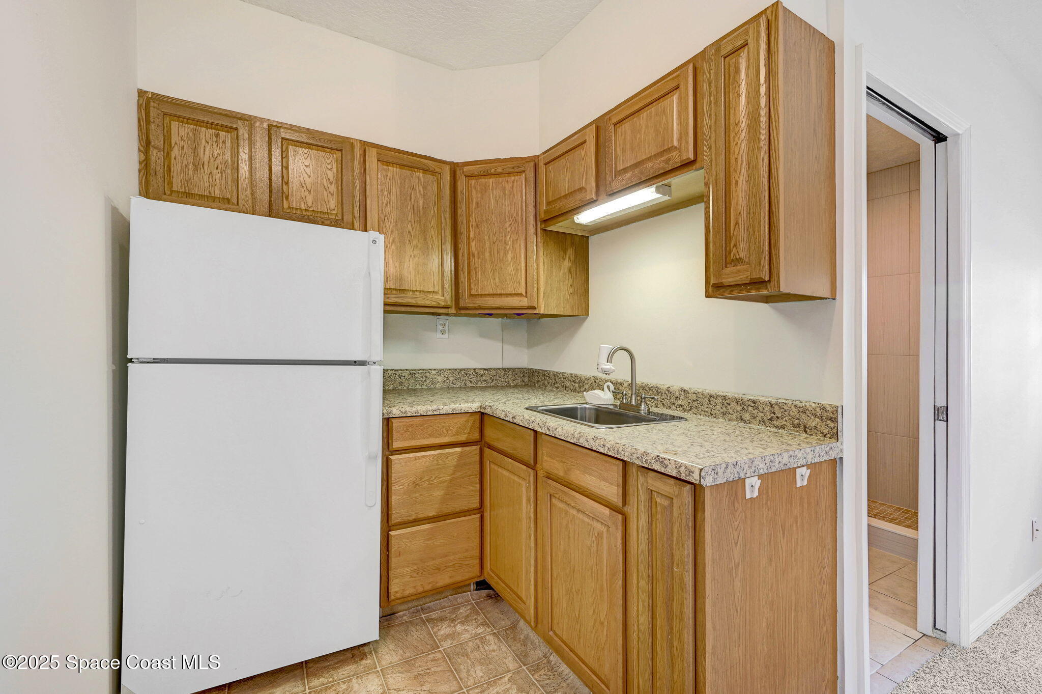 6094 Cardiff Avenue Cocoa, FL 32927 - Photo 36 of 48 a kitchen with a refrigerator a stove top oven a sink and dishwasher