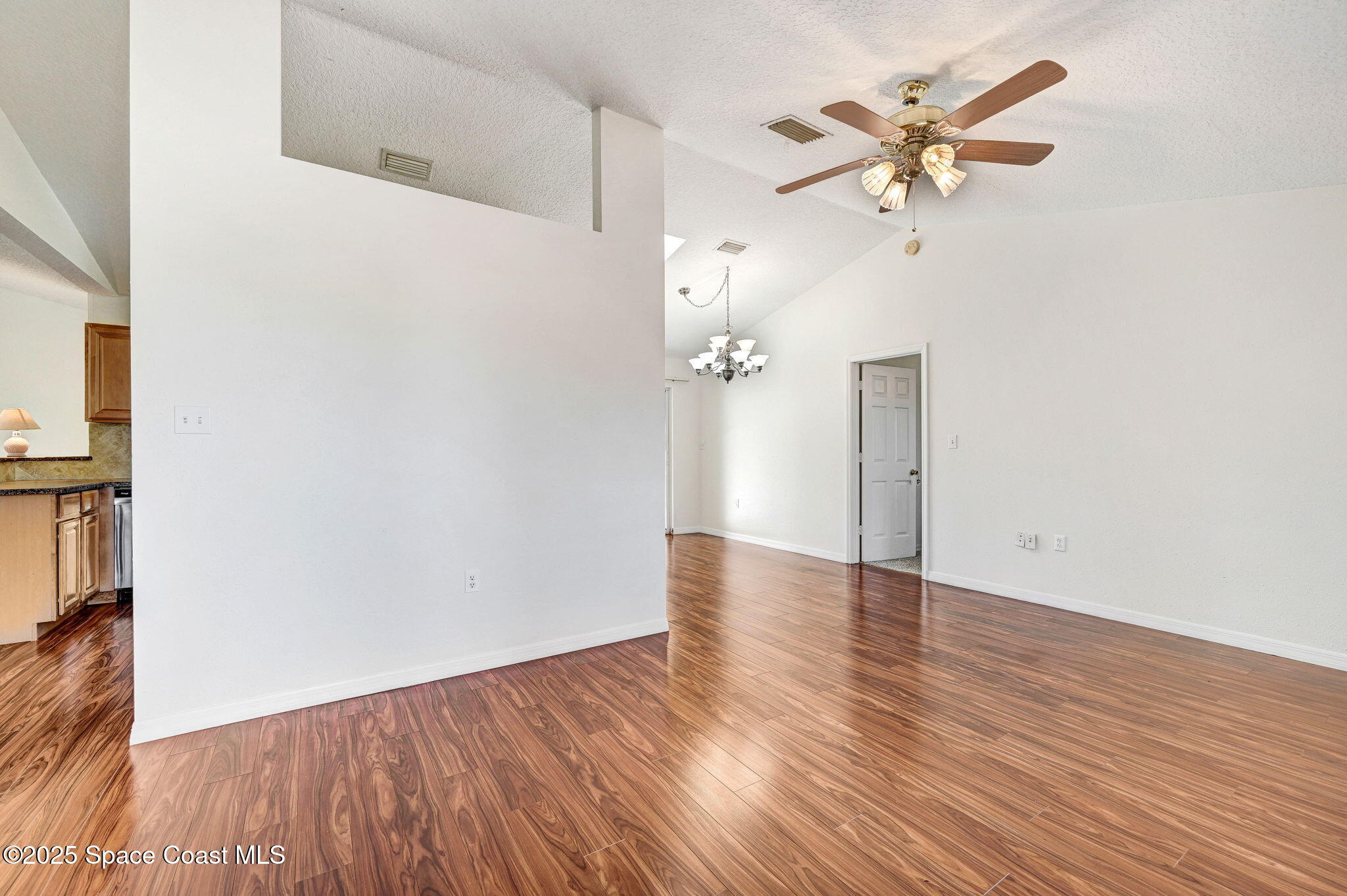6094 Cardiff Avenue Cocoa, FL 32927 - Photo 9 of 48 an empty room with wooden floor and ceiling fan