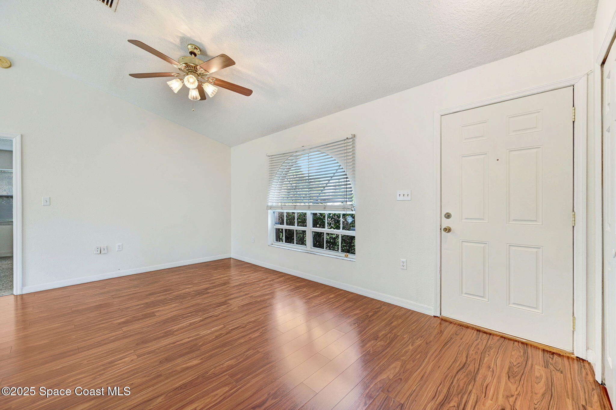 6094 Cardiff Avenue Cocoa, FL 32927 - Photo 10 of 48 a view of an empty room with wooden floor and a window