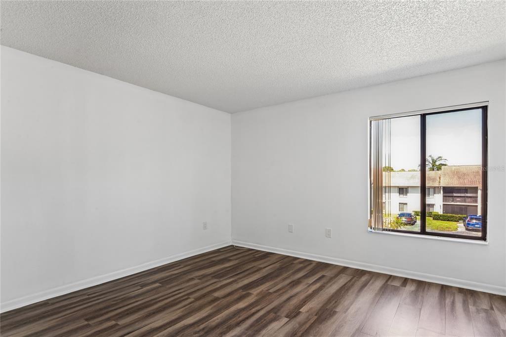 2522 Pine Ridge Way South, Unit D2 Palm Harbor, FL 34684 - Photo 17 of 38 a view of an empty room with window and wooden floor