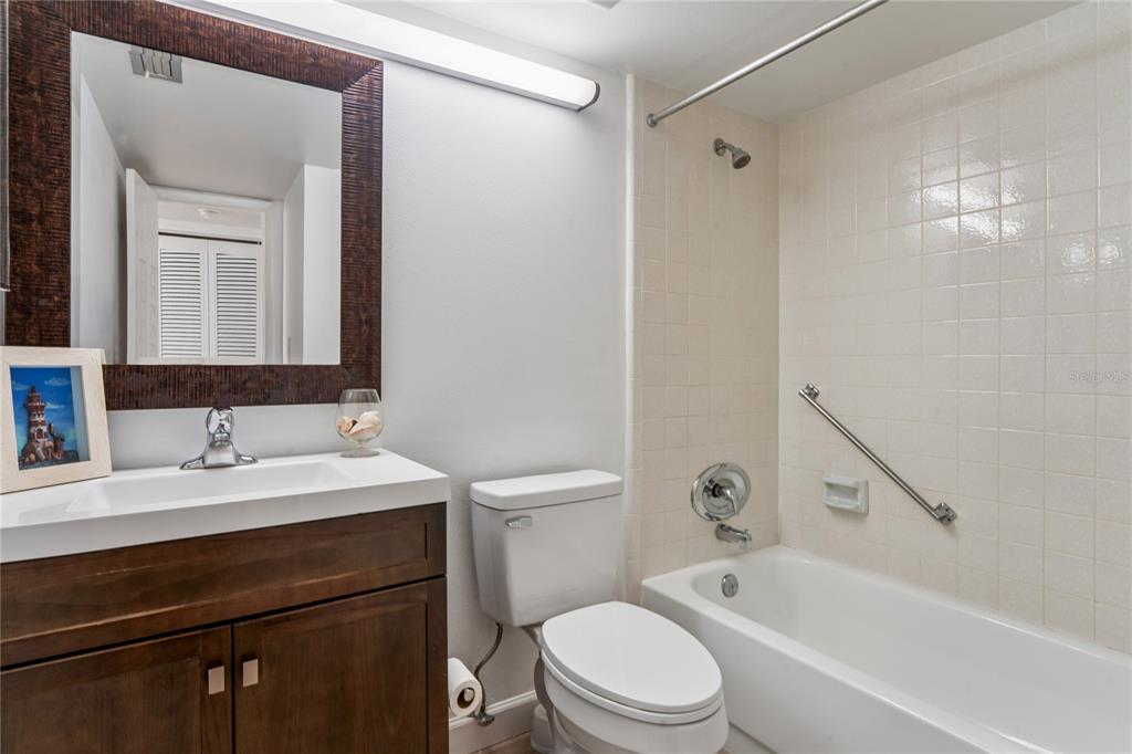 2522 Pine Ridge Way South, Unit D2 Palm Harbor, FL 34684 - Photo 23 of 38 a bathroom with a bathtub shower sink vanity mirror and toilet