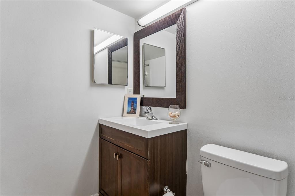 2522 Pine Ridge Way South, Unit D2 Palm Harbor, FL 34684 - Photo 24 of 38 a bathroom with a toilet sink and mirror