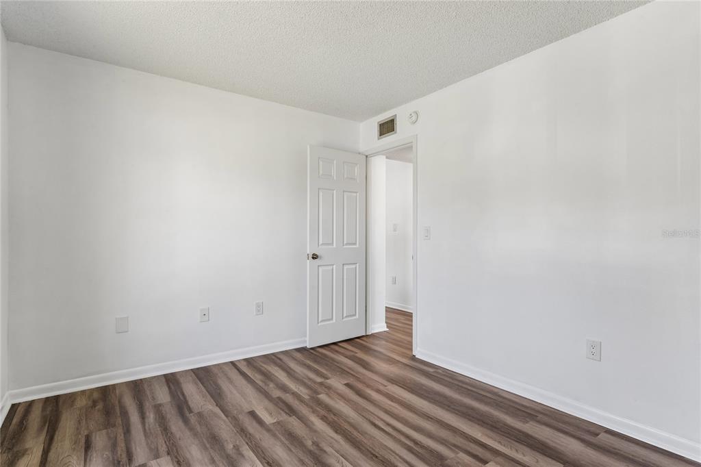 2522 Pine Ridge Way South, Unit D2 Palm Harbor, FL 34684 - Photo 27 of 38 a view of an empty room with wooden floor