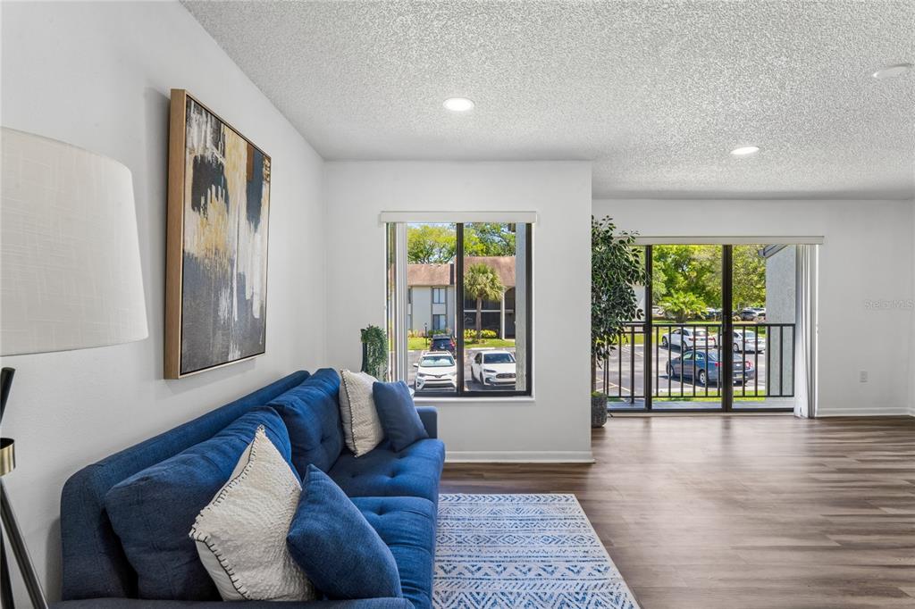 2522 Pine Ridge Way South, Unit D2 Palm Harbor, FL 34684 - Photo 7 of 38 a living room with furniture and large windows