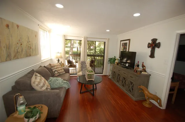 a living room with furniture and a flat screen tv with wooden floor