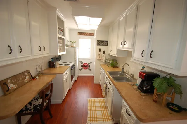 a kitchen with kitchen island granite countertop lots of counter top space and stainless steel appliances