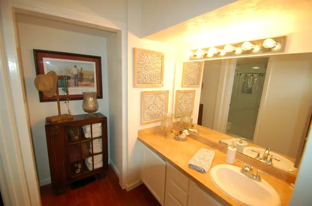 a bathroom with a tub a sink and a large mirror