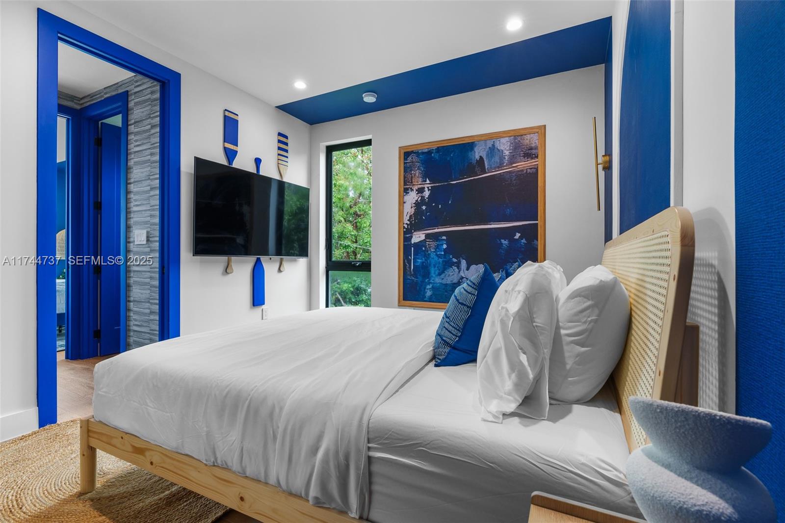 408 Northwest 52nd Street Miami, FL 33127 - Photo 33 of 73 a bedroom with a bed and a flat screen tv