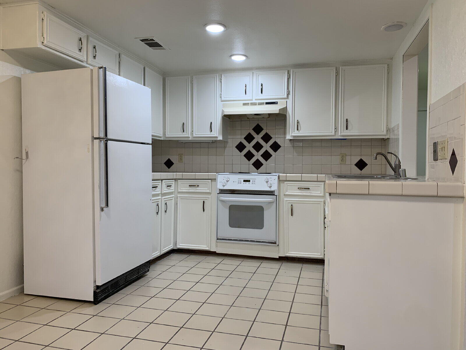 7201 Memphis Avenue, Unit B Lubbock, TX 79423 - Photo 4 of 14 a kitchen with a white stove top oven and white stainless steel appliances