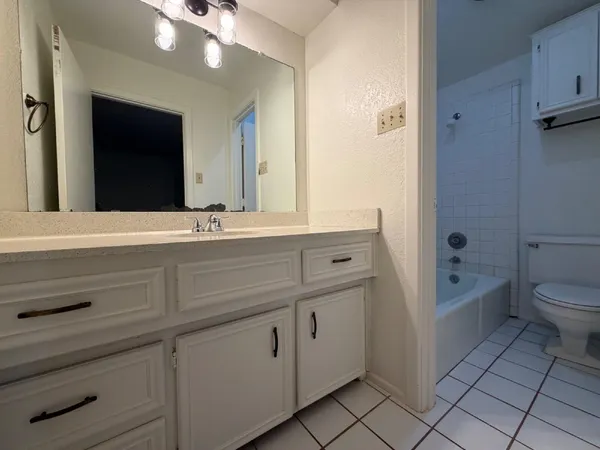 a bathroom with a sink a toilet and mirror