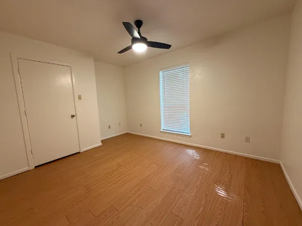 an empty room with closet and windows