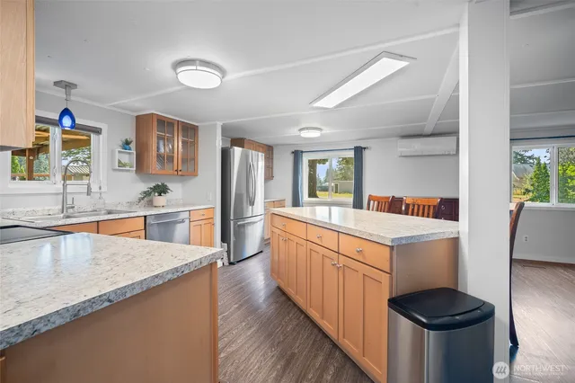 a kitchen with stainless steel appliances granite countertop a kitchen island a stove a sink and a refrigerator