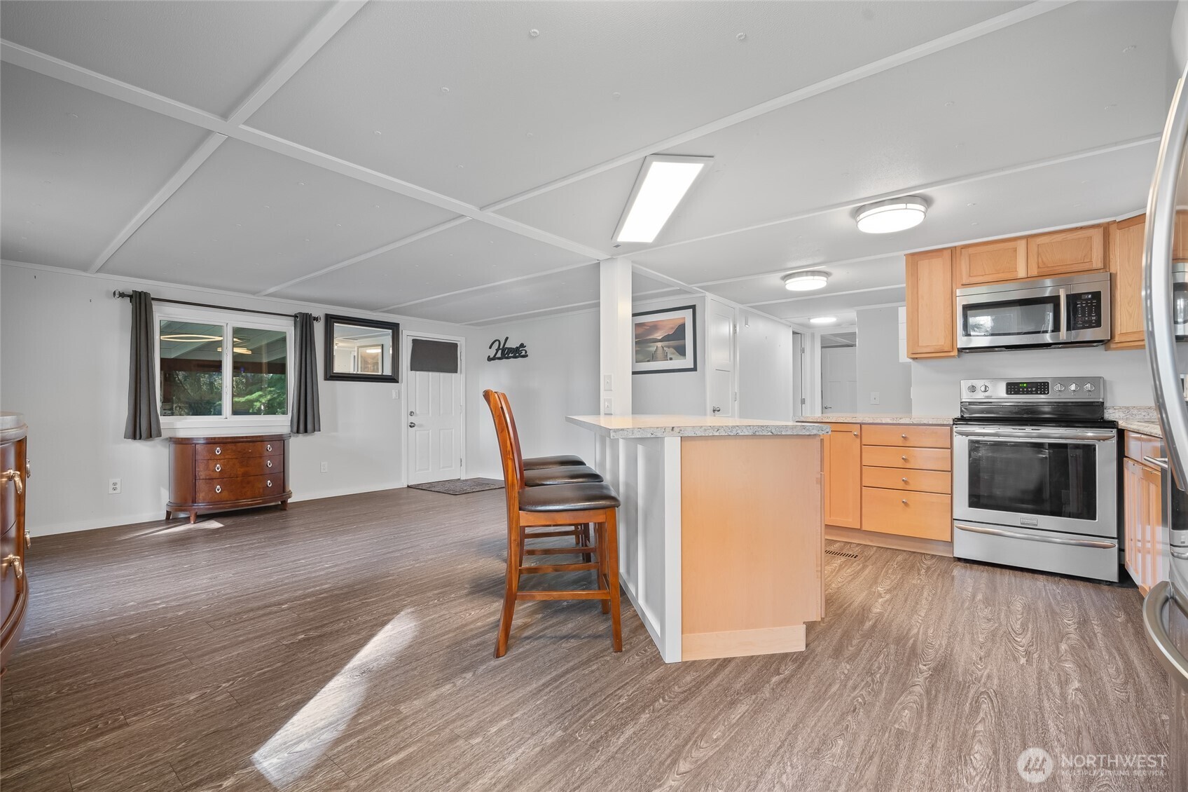 6978 Hannegan Road Lynden, WA 98264 - Photo 12 of 37 a kitchen with granite countertop a stove and a wooden floors