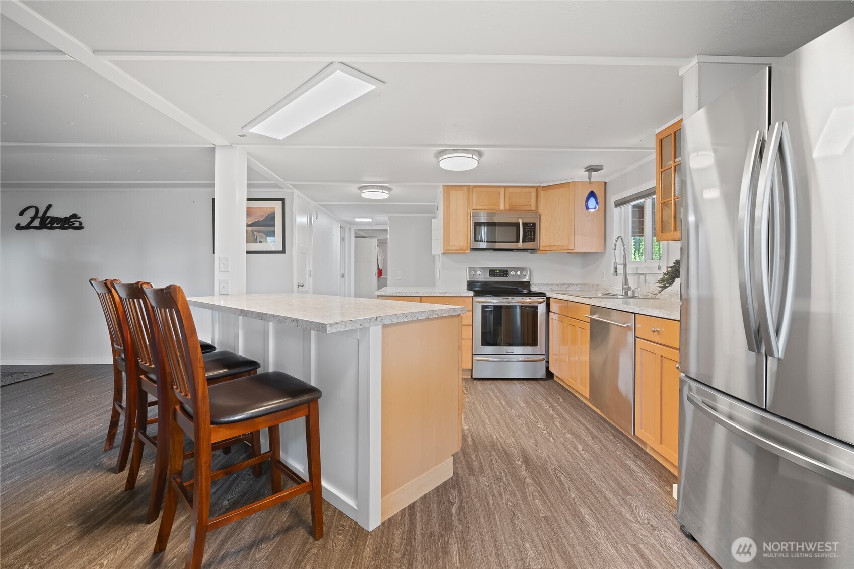 6978 Hannegan Road Lynden, WA 98264 - Photo 13 of 37 a kitchen with stainless steel appliances granite countertop a dining table chairs a refrigerator and cabinets