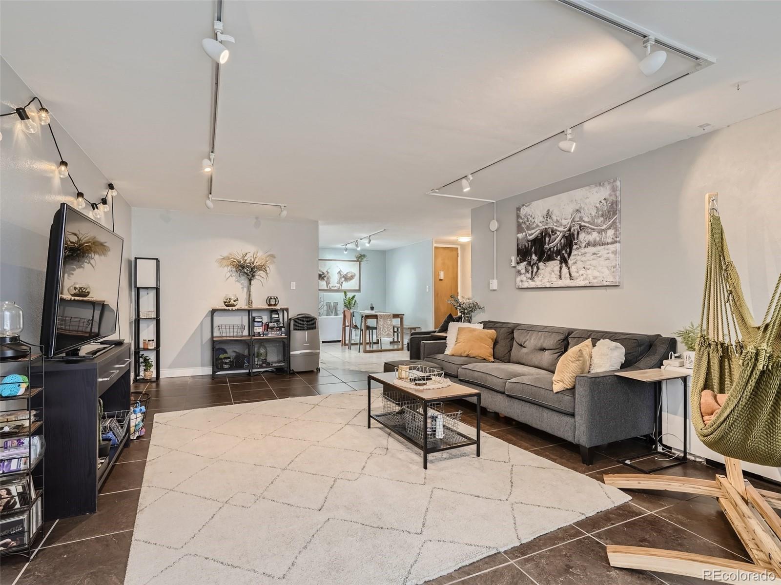 1155 Ash Street, Unit 202 Denver, CO 80220 - Photo 2 of 21 a living room with furniture a rug and a flat screen tv