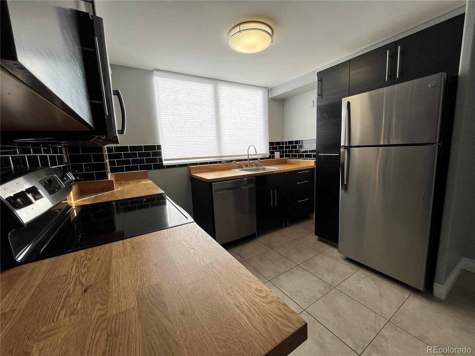 1155 Ash Street, Unit 202 Denver, CO 80220 - Photo 21 of 21 a kitchen with stainless steel appliances granite countertop a refrigerator a sink and a stove