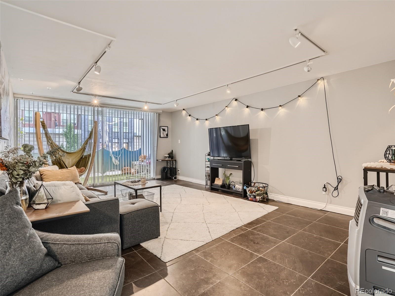 1155 Ash Street, Unit 202 Denver, CO 80220 - Photo 3 of 21 a living room with furniture a flat screen tv and a large window