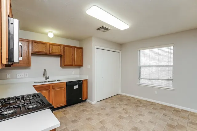 a kitchen with stainless steel appliances a stove a sink and a microwave