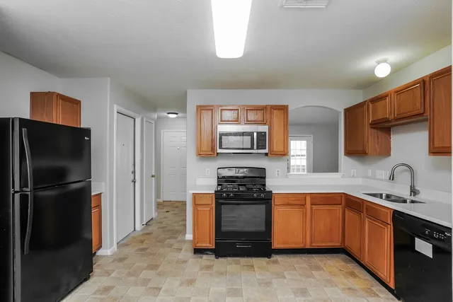 a kitchen with stainless steel appliances granite countertop a refrigerator and a sink