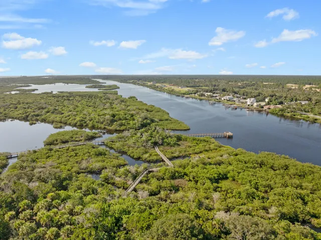 an aerial view of ocean and residential houses with outdoor space