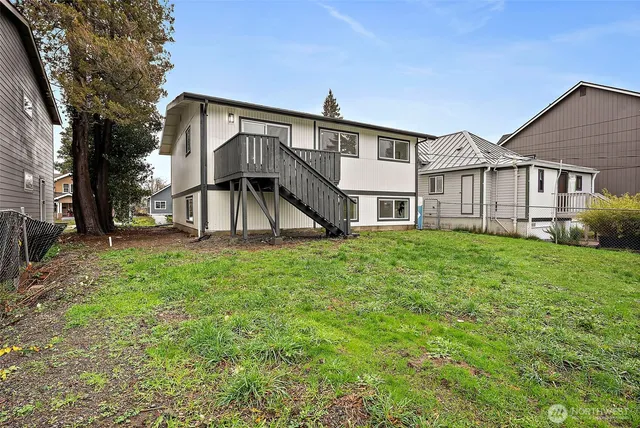 a view of a big house with a big yard and large tree