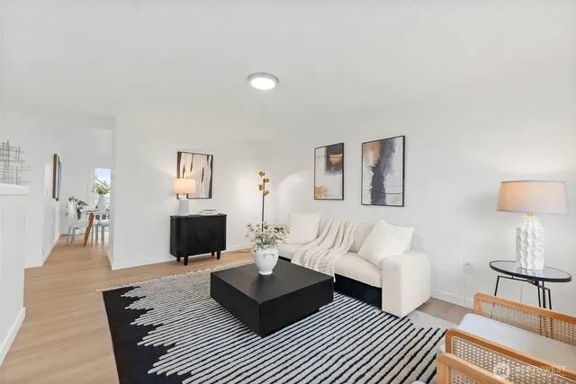 a living room with furniture a lamp on the rug and a fireplace