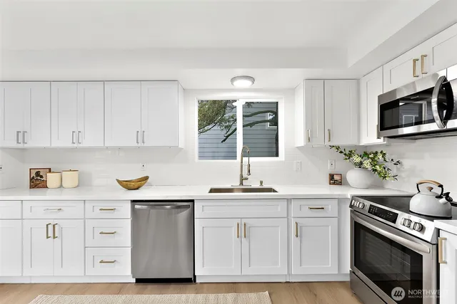 a kitchen with stainless steel appliances a refrigerator sink and stove