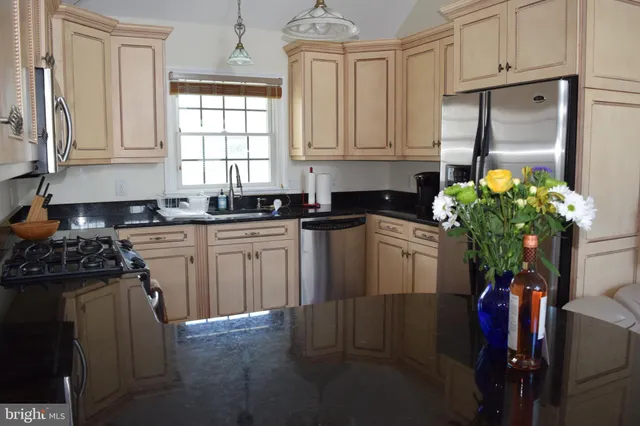 a kitchen with stainless steel appliances granite countertop a refrigerator sink and cabinets