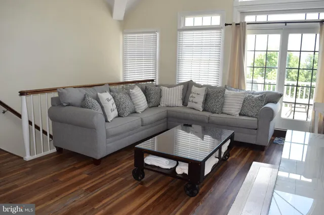 a living room with furniture a wooden floor and a window