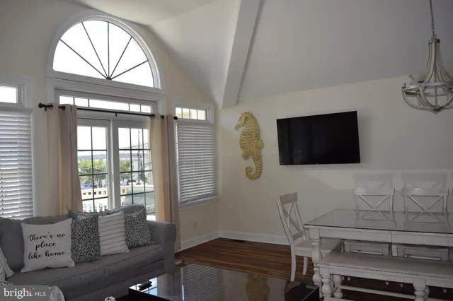 a living room with furniture a flat screen tv and a floor to ceiling window