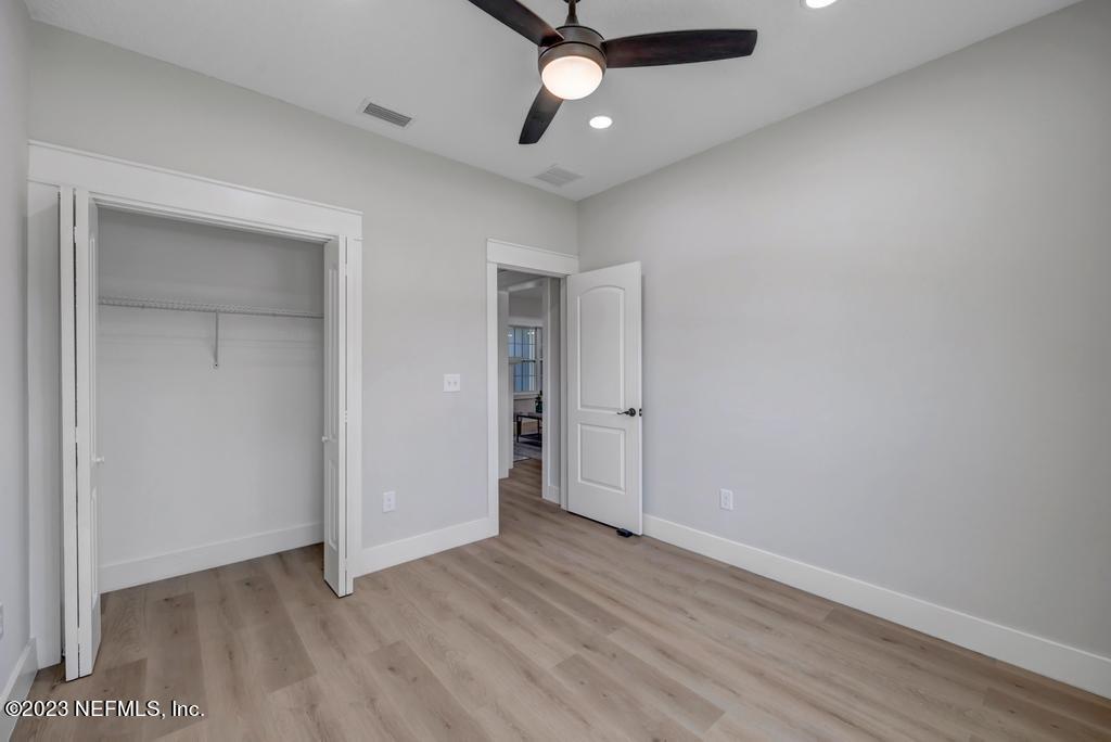 1281 Glen Laura Road Jacksonville, FL 32205 - Photo 25 of 33 an empty room with wooden floor ceiling fan and windows