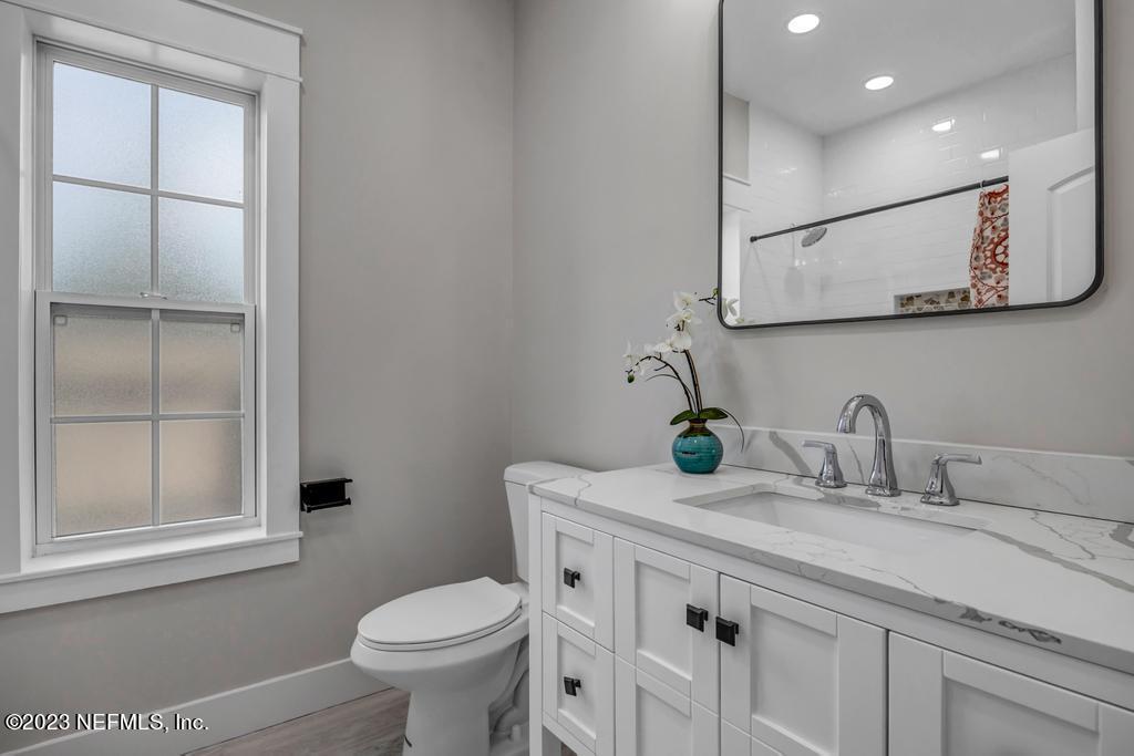 1281 Glen Laura Road Jacksonville, FL 32205 - Photo 29 of 33 a bathroom with a granite countertop sink a toilet and a mirror