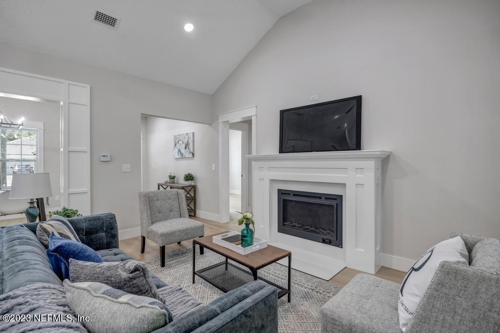 1281 Glen Laura Road Jacksonville, FL 32205 - Photo 5 of 33 a living room with furniture a flat screen tv and a fireplace