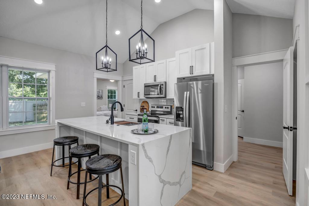 1281 Glen Laura Road Jacksonville, FL 32205 - Photo 8 of 33 a kitchen with stainless steel appliances a dining table a sink cabinets and wooden floor