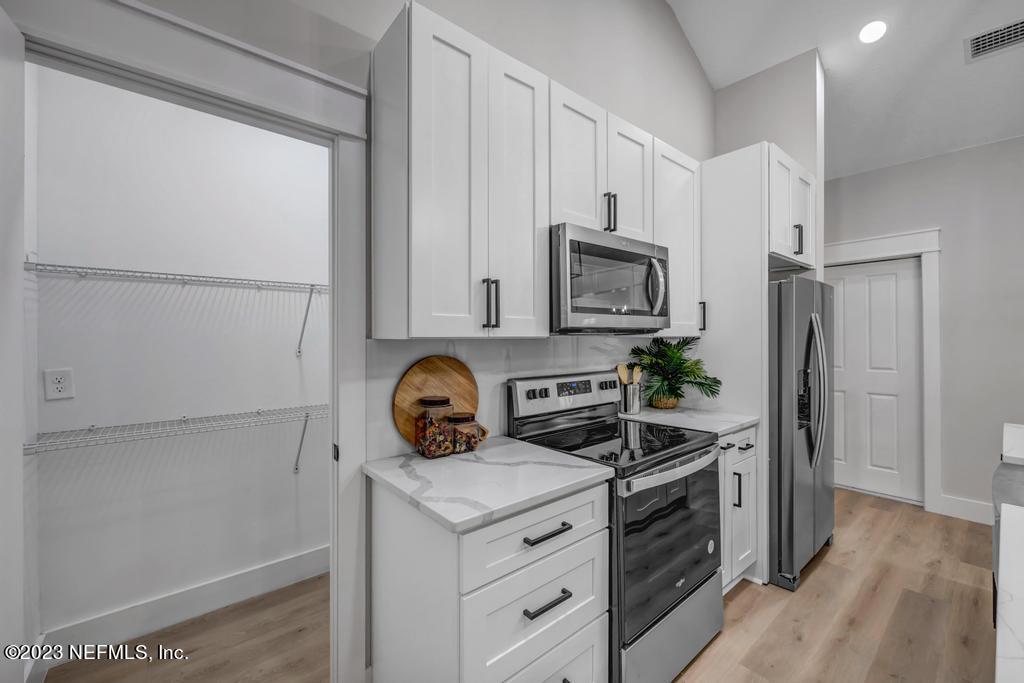 1281 Glen Laura Road Jacksonville, FL 32205 - Photo 9 of 33 a kitchen with appliances a refrigerator and cabinets