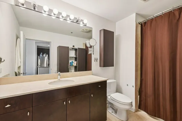 a bathroom with a sink vanity granite and toilet