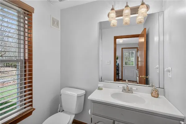 a bathroom with a toilet a sink and mirror