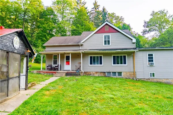 a view of a house with a yard and sitting area