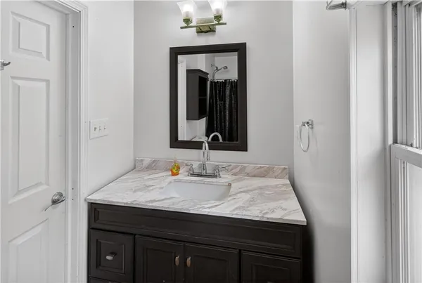 a bathroom with a granite countertop sink and a mirror